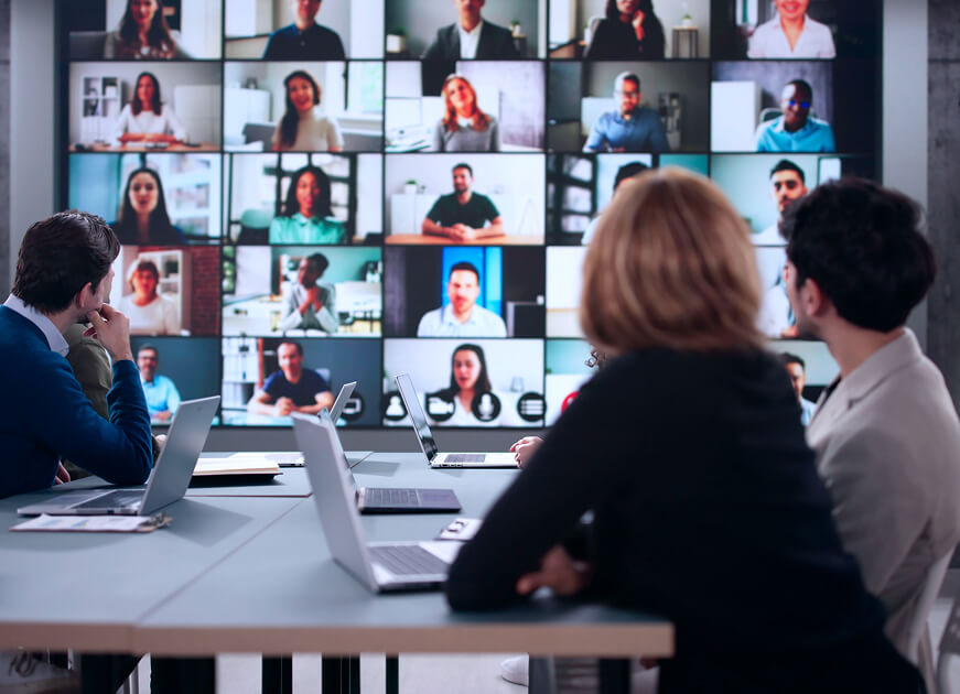 Hybrid team collaborating in person and online, representing RevStar’s digital transformation process.