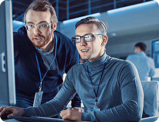 Two IT professionals collaborating at a computer, showcasing RevStar’s digital transformation services.