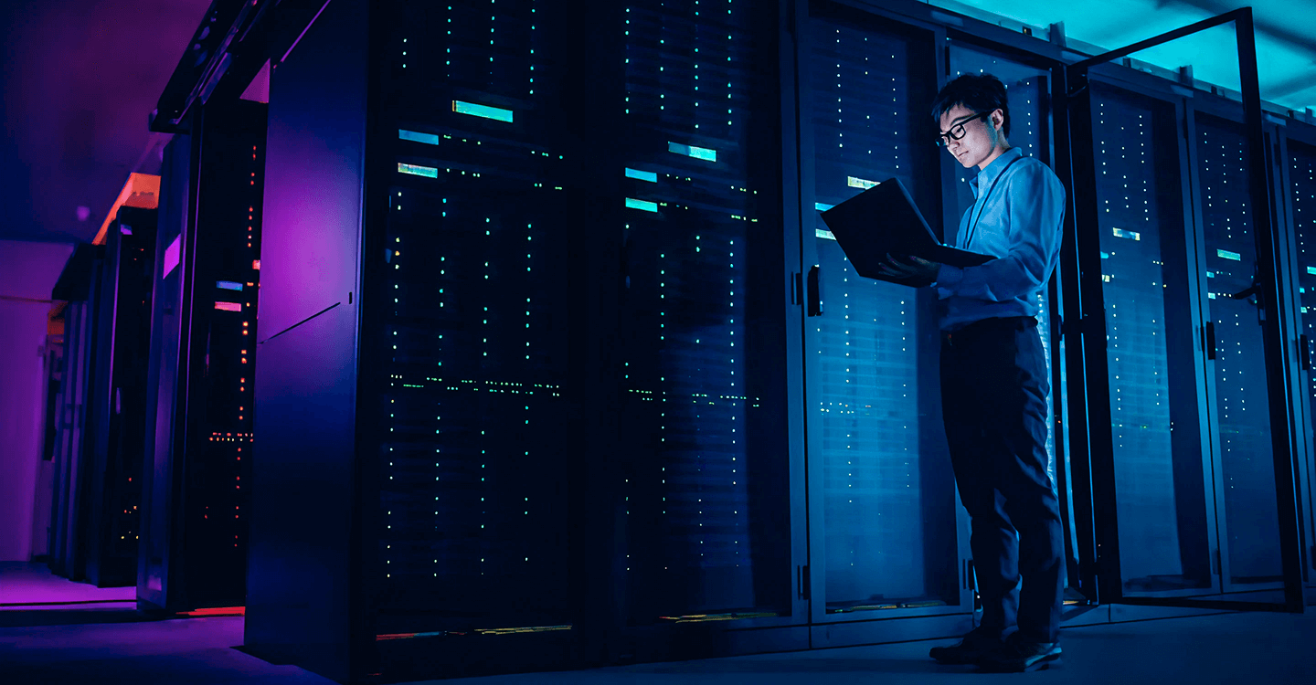 IT professional working on a laptop in a data center, highlighting RevStar as a trusted digital transformation partner.