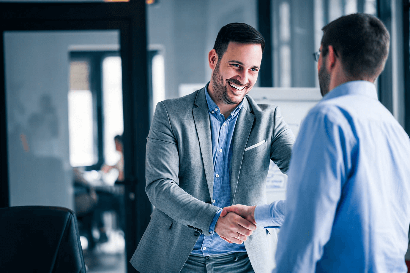 Business leaders shaking hands in agreement, representing the value of an innovation briefing.