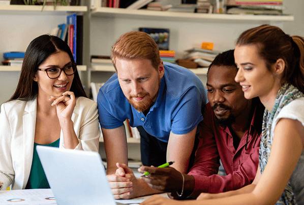 Group of colleagues gathered around a laptop, discussing ideas and collaborating in an office setting.