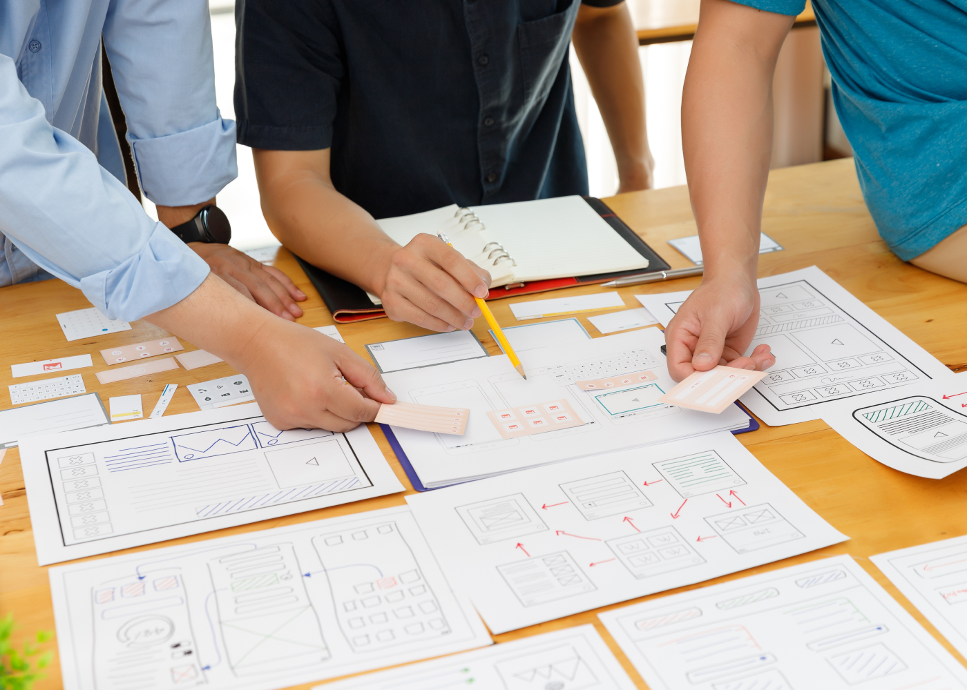 Close up of working professional hands pointing at wireframes on table