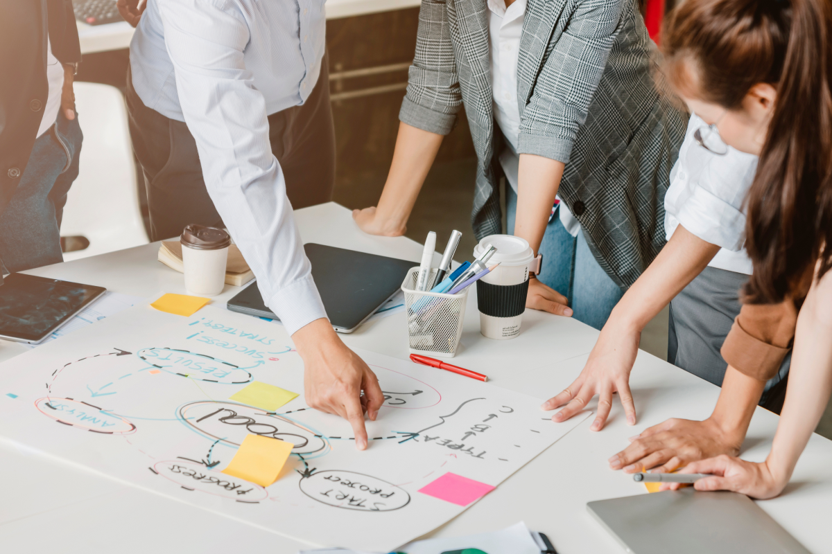 Group of workers looking at a chart while the project manager directs them