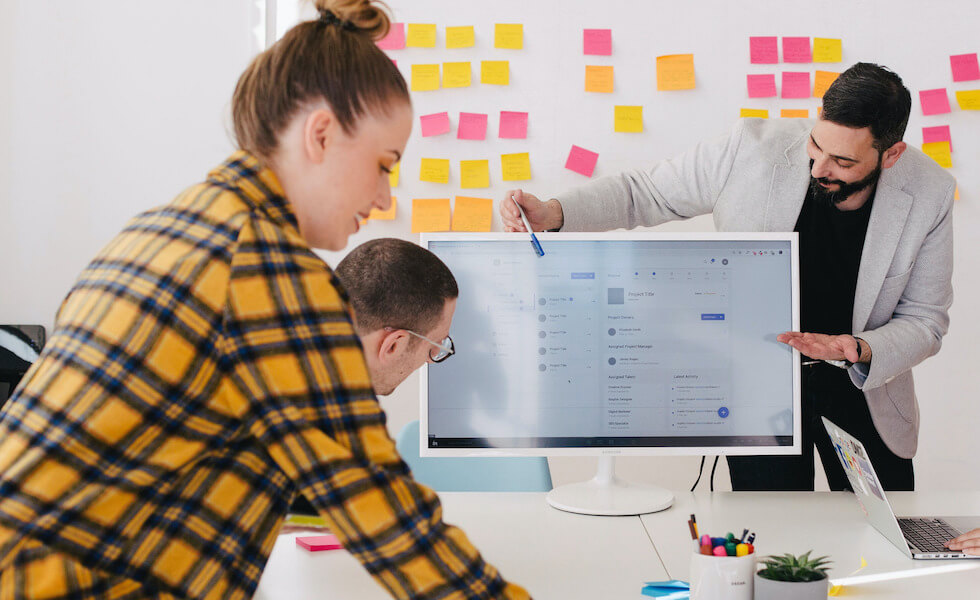 Pair of male working professionals discussing wireframe on desktop